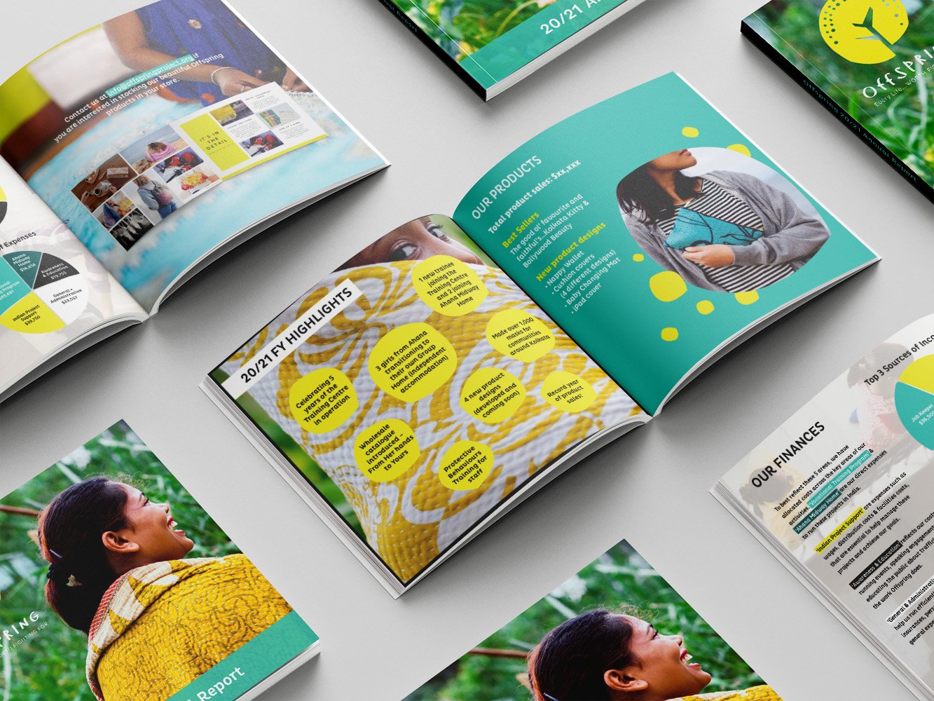 A set of square-shaped annual reports open on a table, revealing different pages. Statistics, products and business highlights are displayed.