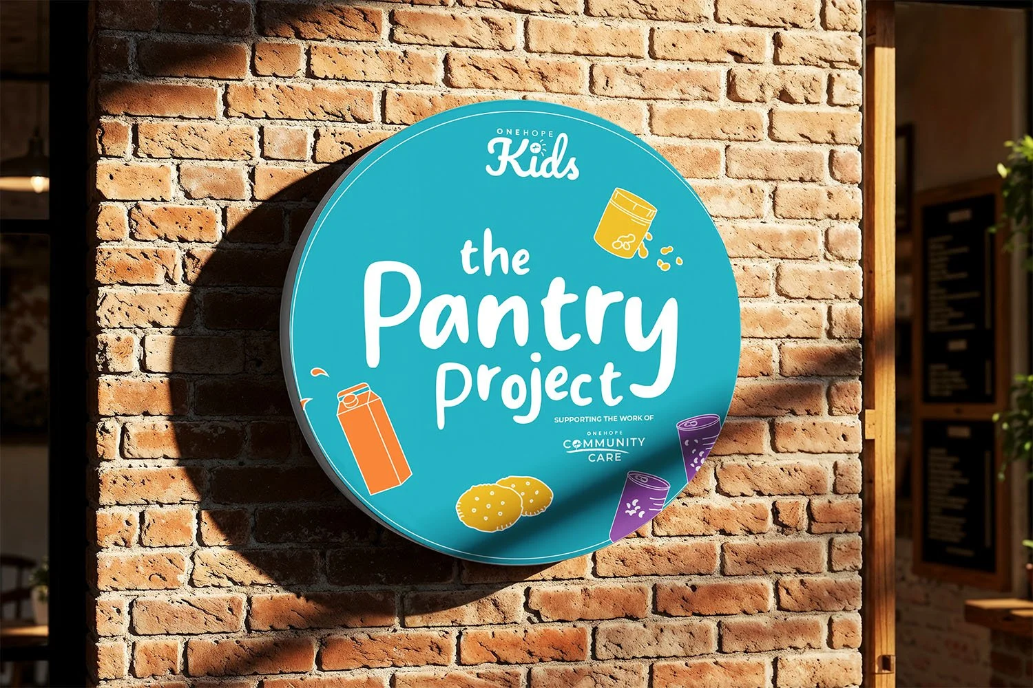 Round Pantry Project sign mounted on brick exterior wall.