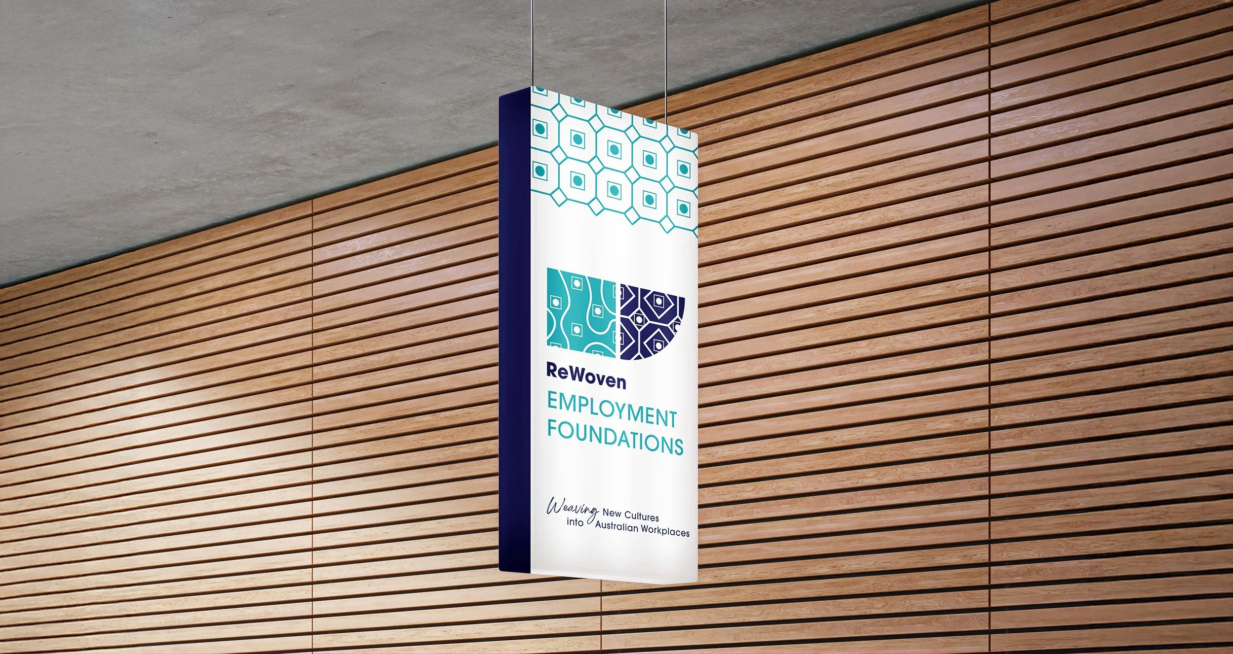 A hanging sign for ReWoven Employment Foundations.