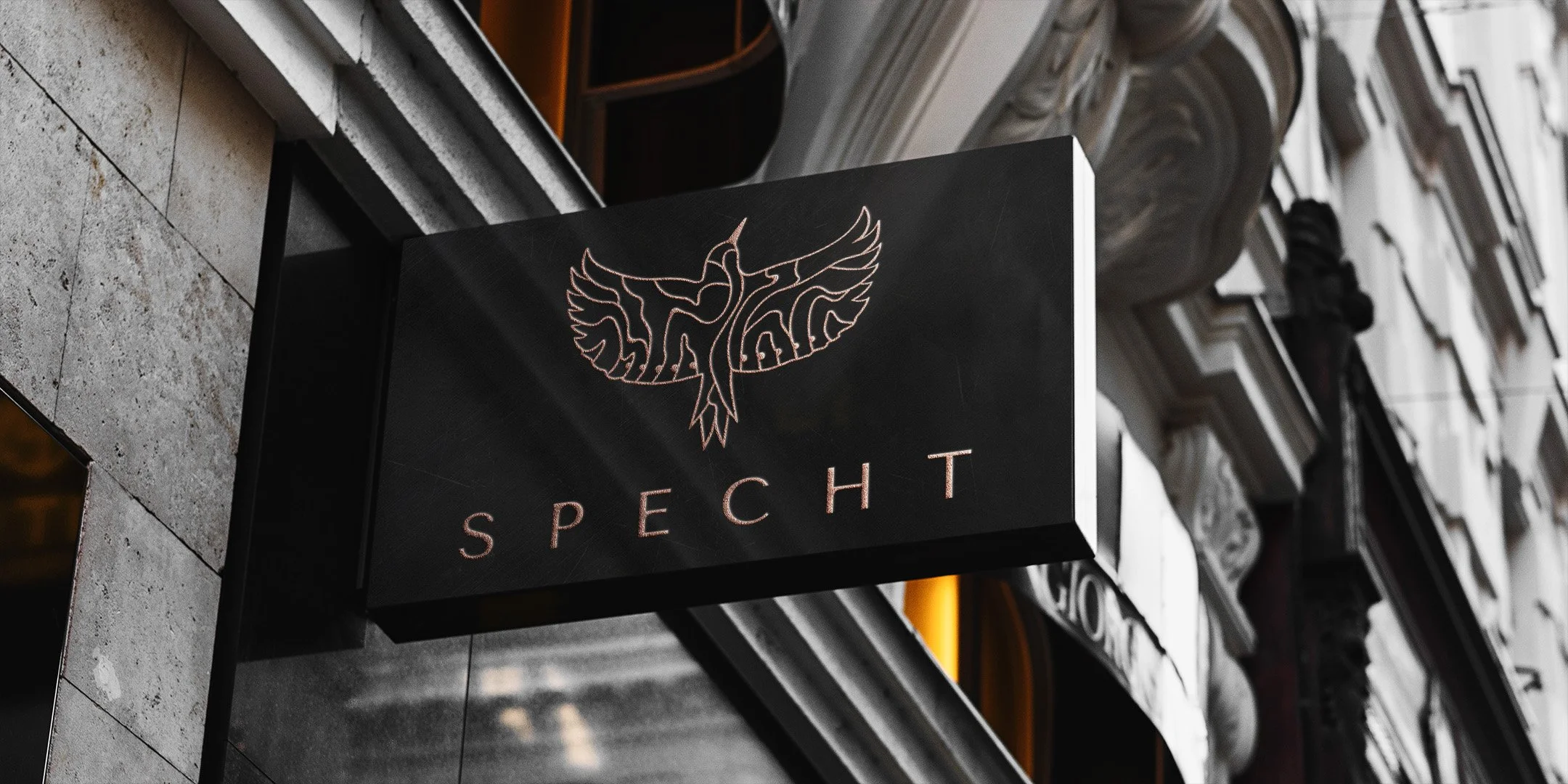 Exterior sign for Specht, with raised-gold logo.