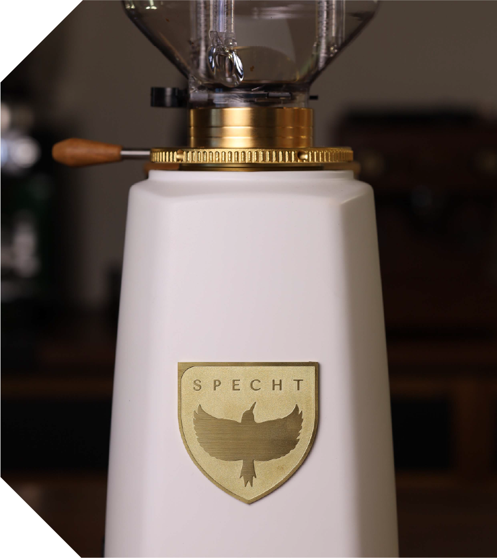 A white Specht coffee grinder featuring a gold Specht badge.