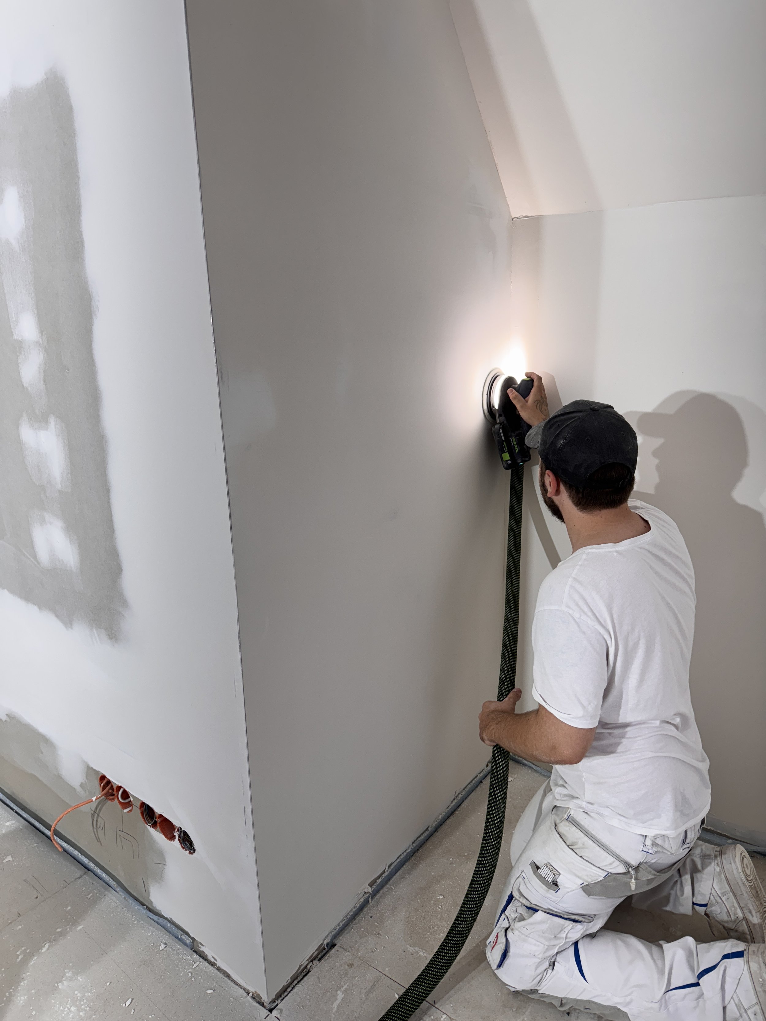 Unser Maler schleift eine gespachtelte Wand