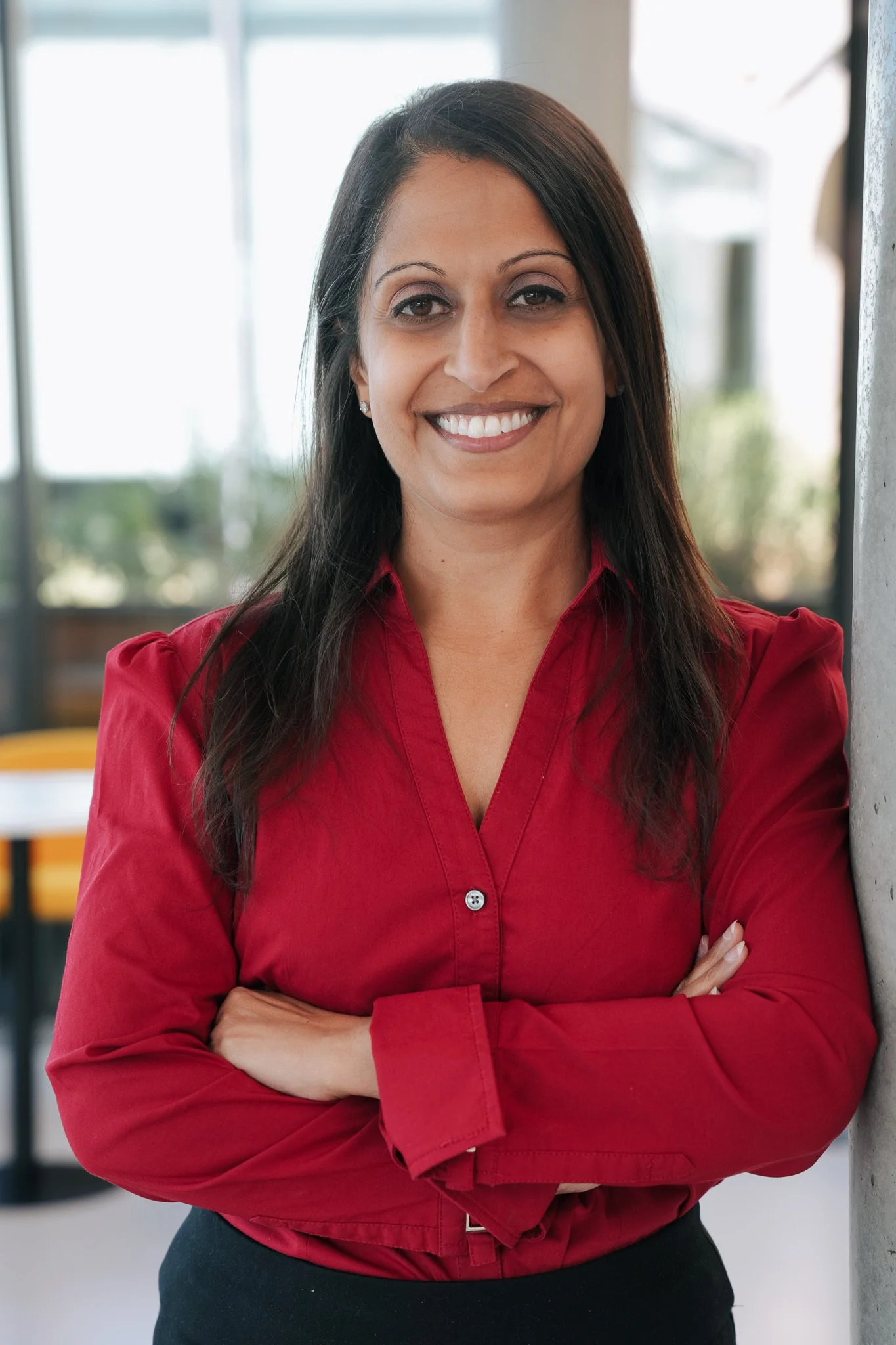 Photo of the VP of Strategy and Business Development from Reflex Aerospace with long brown hair wearing a black blazer and white top against a plain light background.