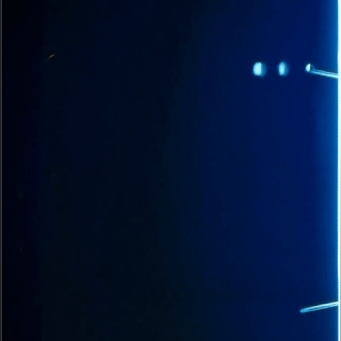 Dark blue screen with small bright lights at the top right and bottom right corners.