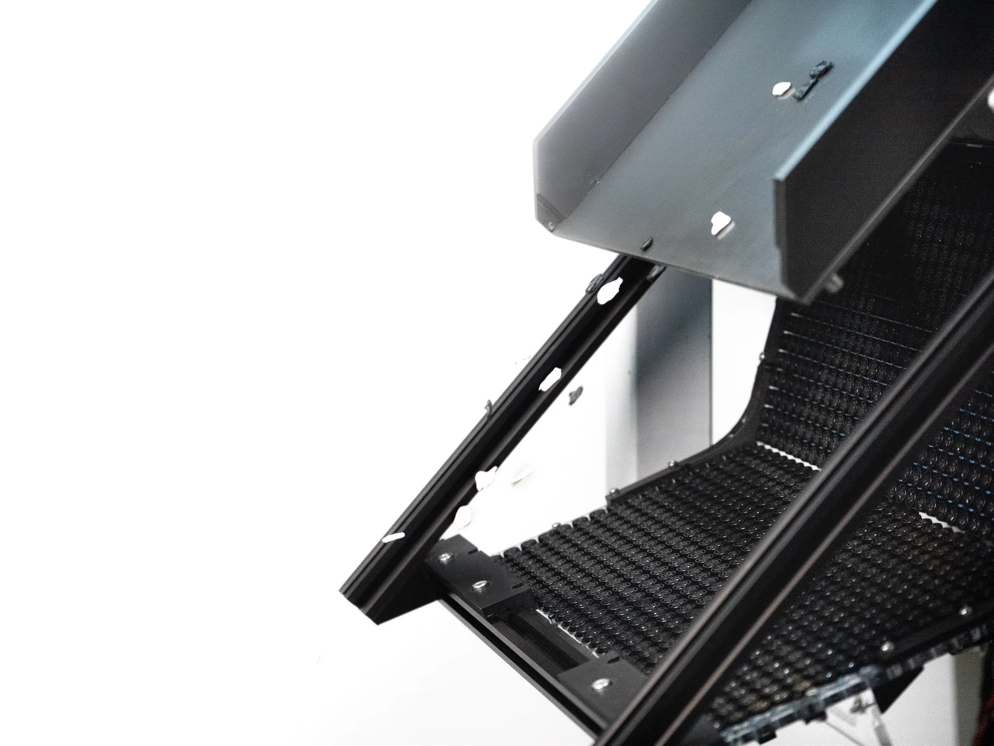 A close-up of a modern electronic device, possibly a scanner or photocopier, with black and metallic grey components.