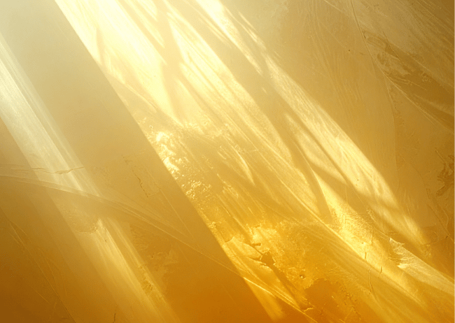 Close-up of a shiny, gold-colored metallic surface with abstract reflections.