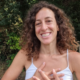 Woman with curly hair smiling outdoors