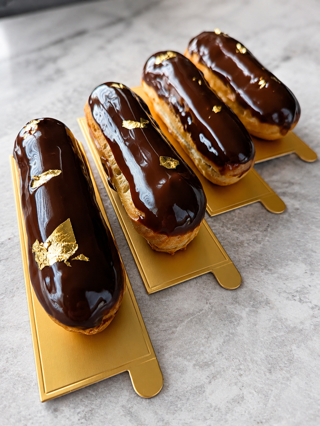 4 chocolate eclairs on gold bases for Our Story page
