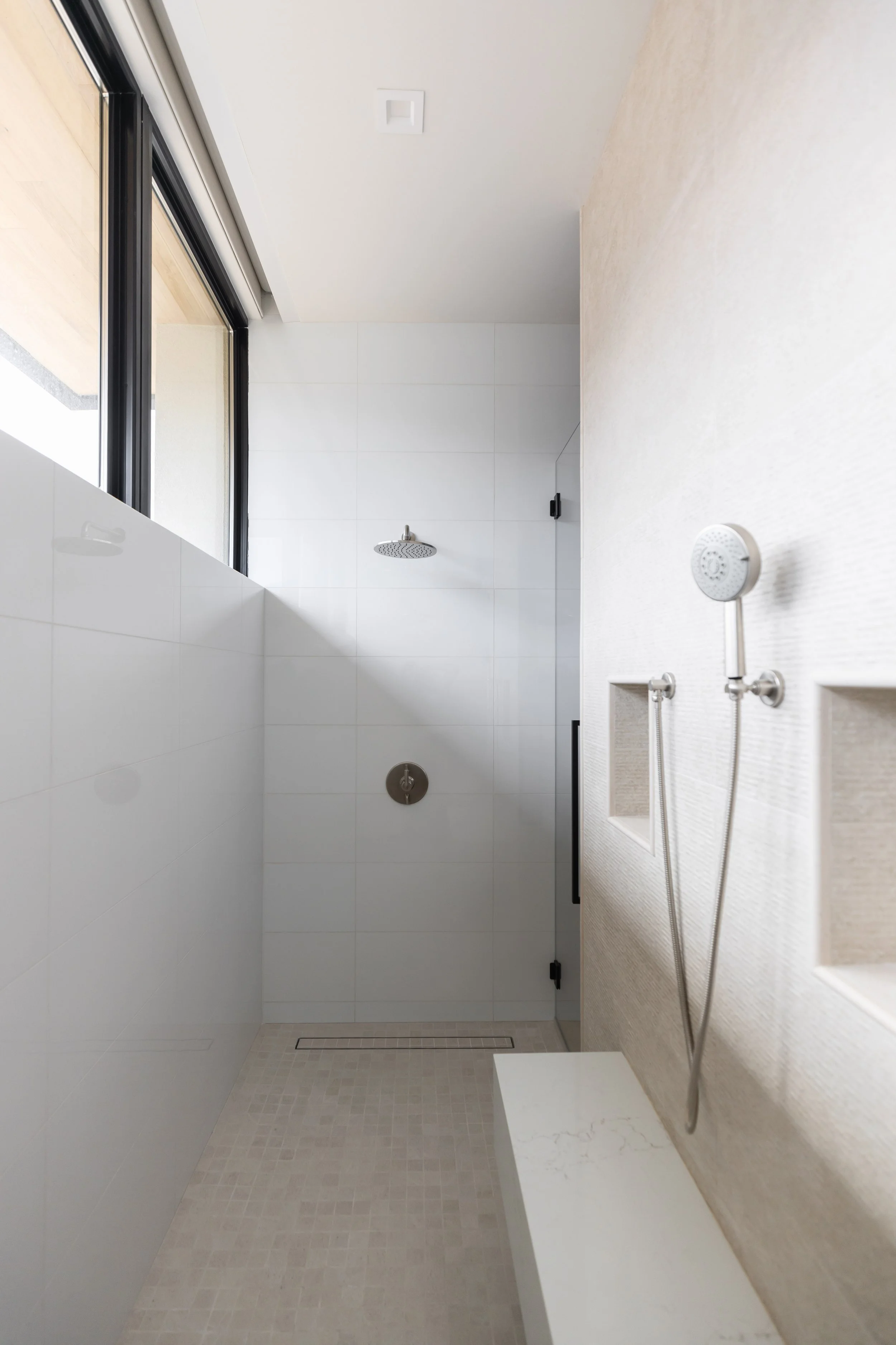 Custom shower tile detailing with recessed niches and built-in bench in a Scottsdale home.