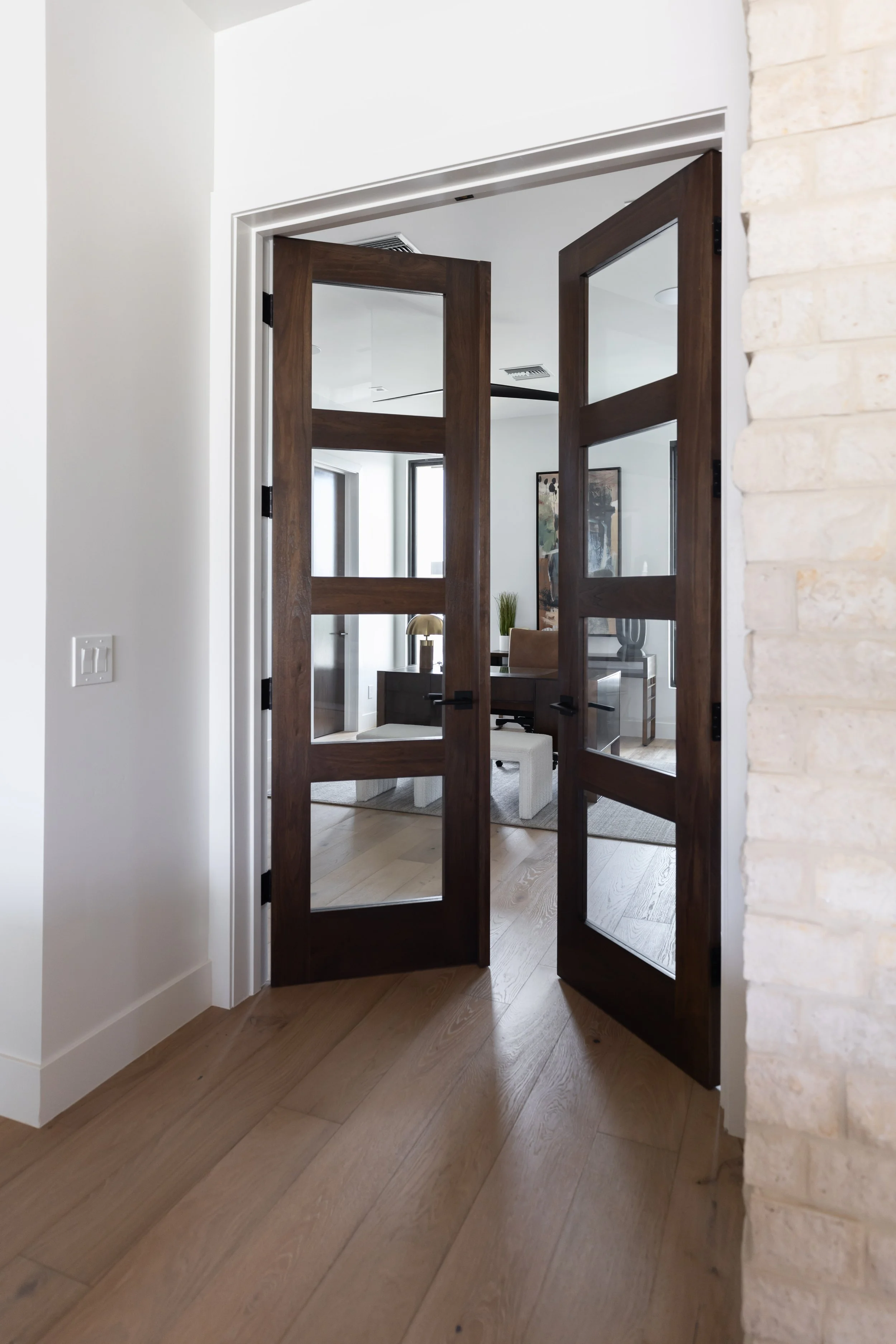 Dark wood and glass double doors opening into a modern Scottsdale home office