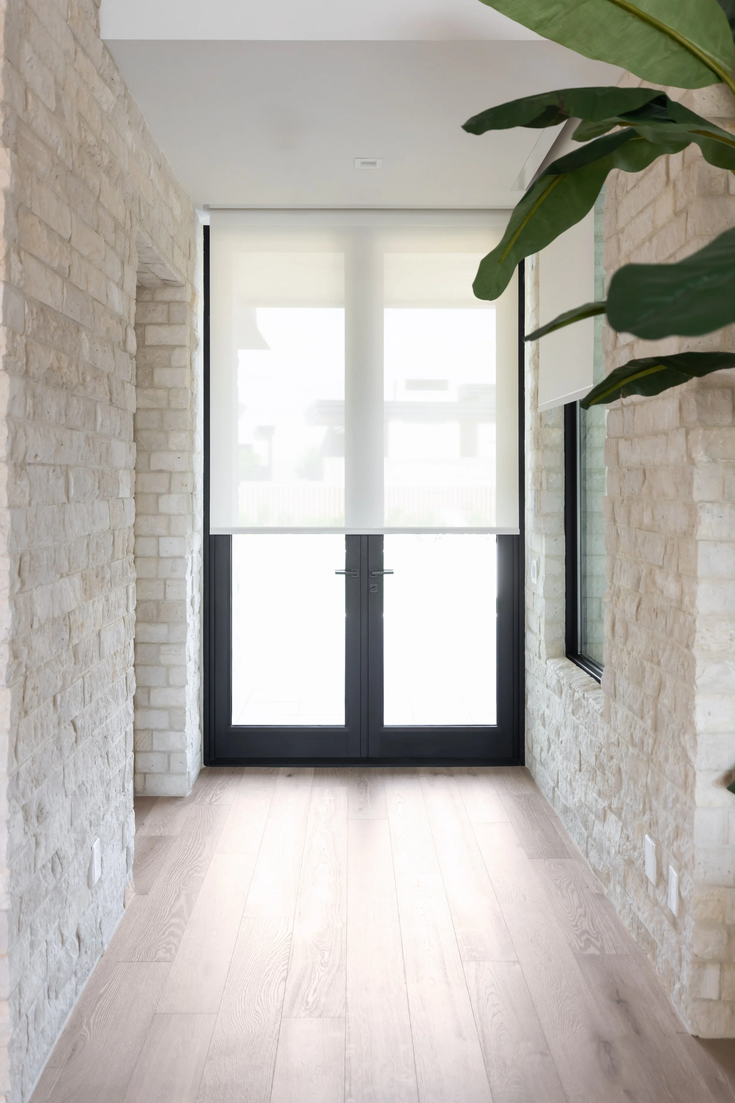 Light wood flooring and natural stone walls in a modern Scottsdale custom home.