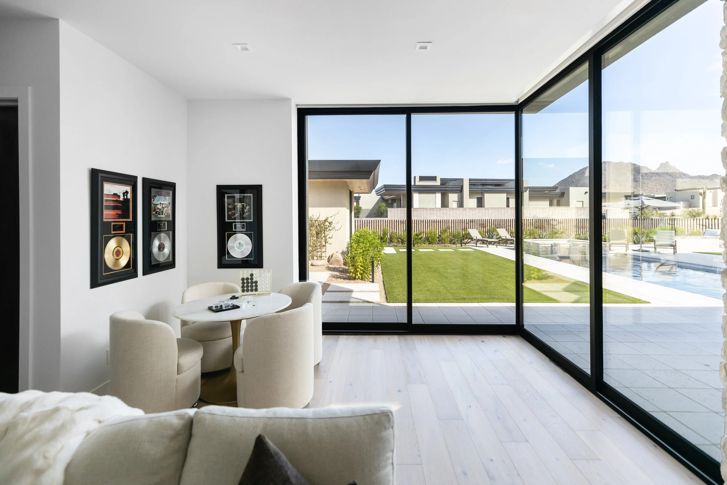 Scottsdale custom home game room with floor-to-ceiling black windows overlooking pool and desert mountains