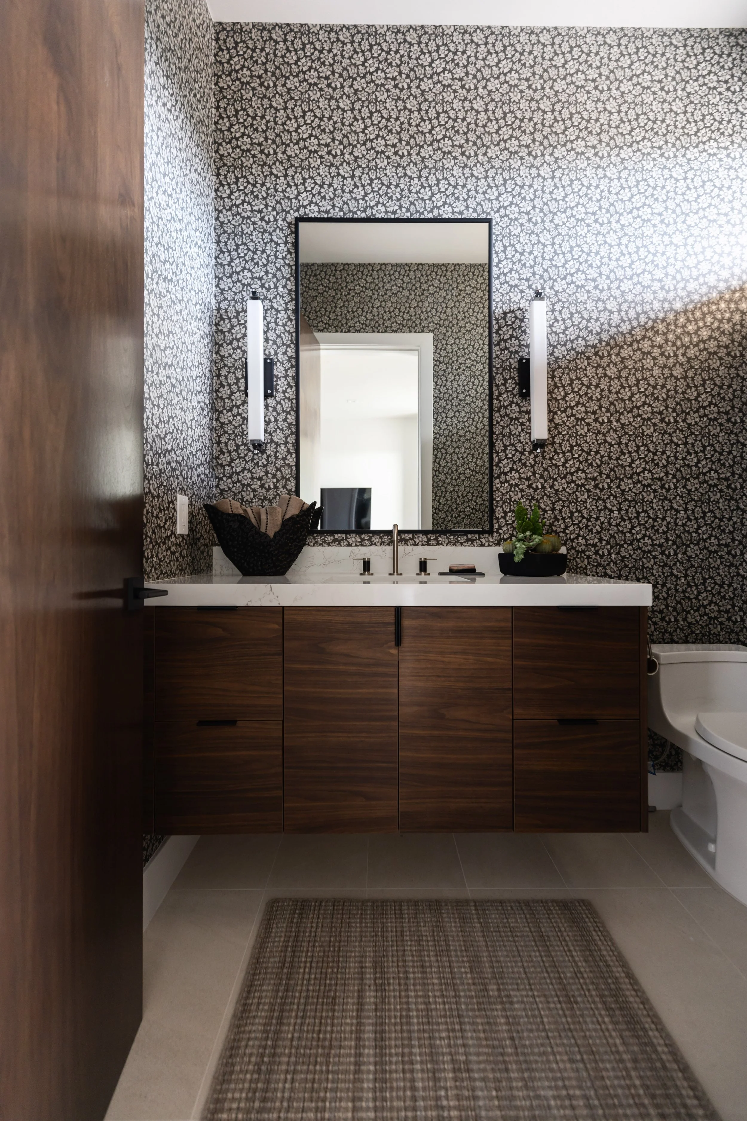Scottsdale powder room with custom vanity, wallpaper and modern sconces designed by Ashley Marie Interiors.