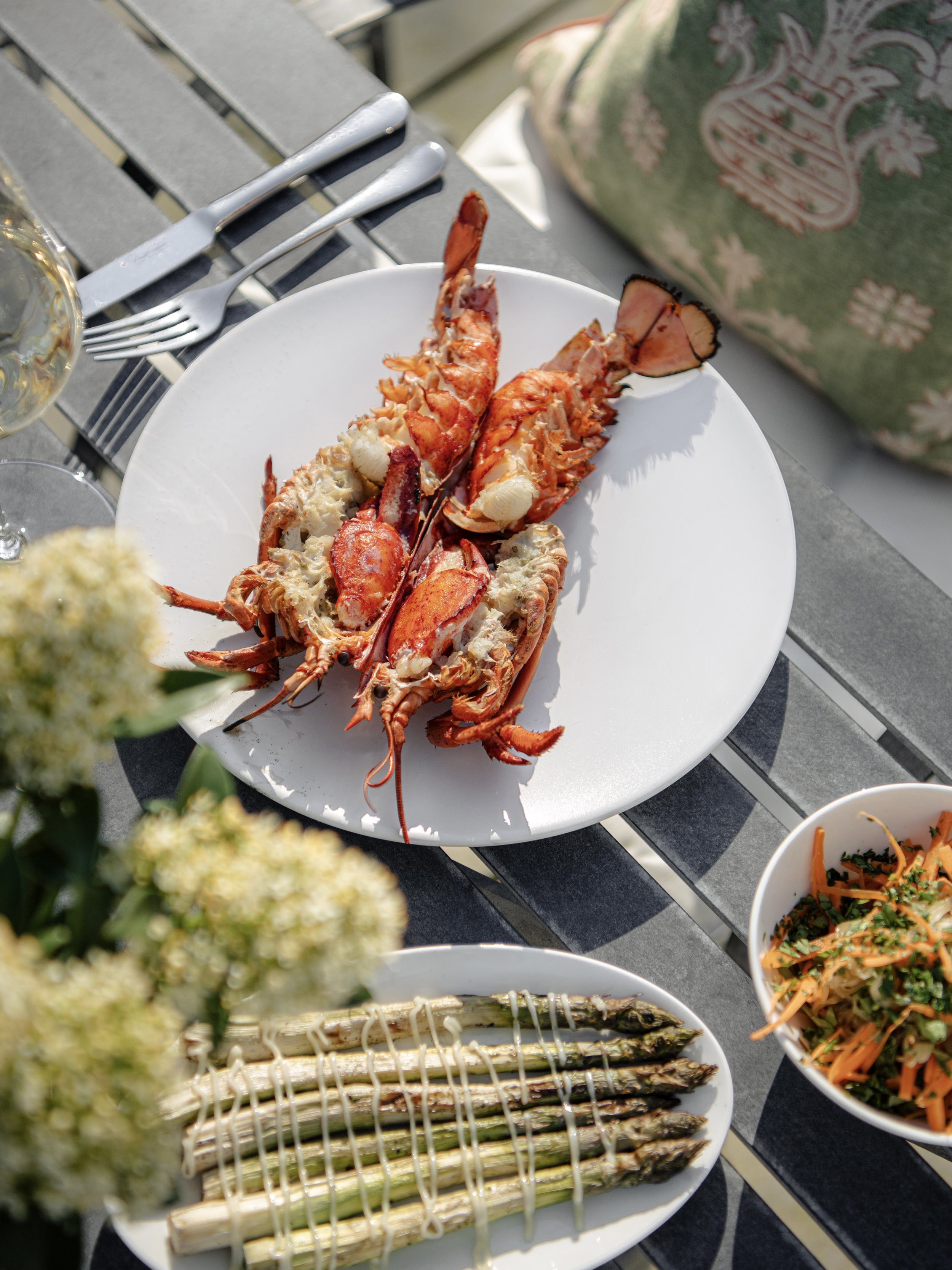 A luxury Father's Day BBQ lunch at Woodcote featuring grilled lobster tail, seasonal asparagus, and fresh salads on the terrace.