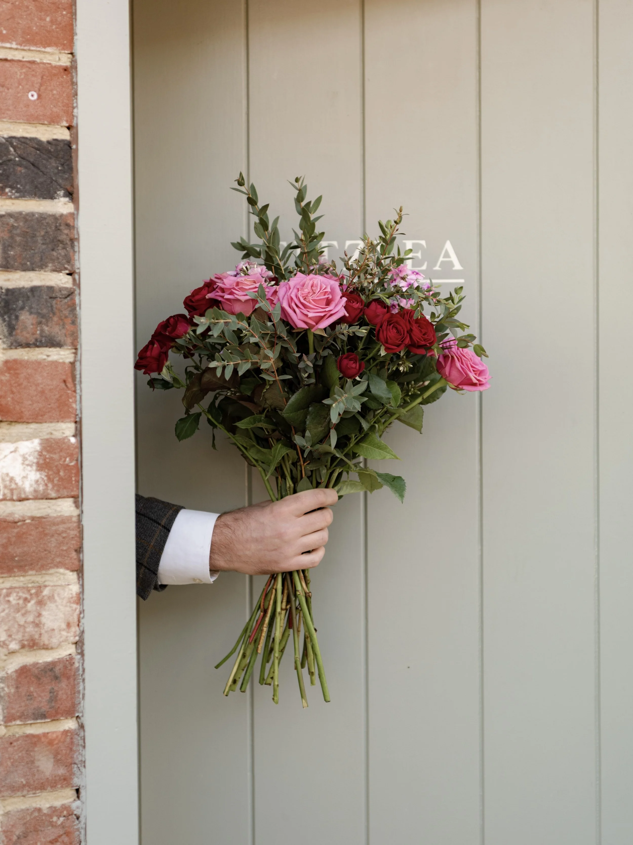 Luxury Valentine’s Day rose bouquet held in front of a guest room door at The Woodcote.