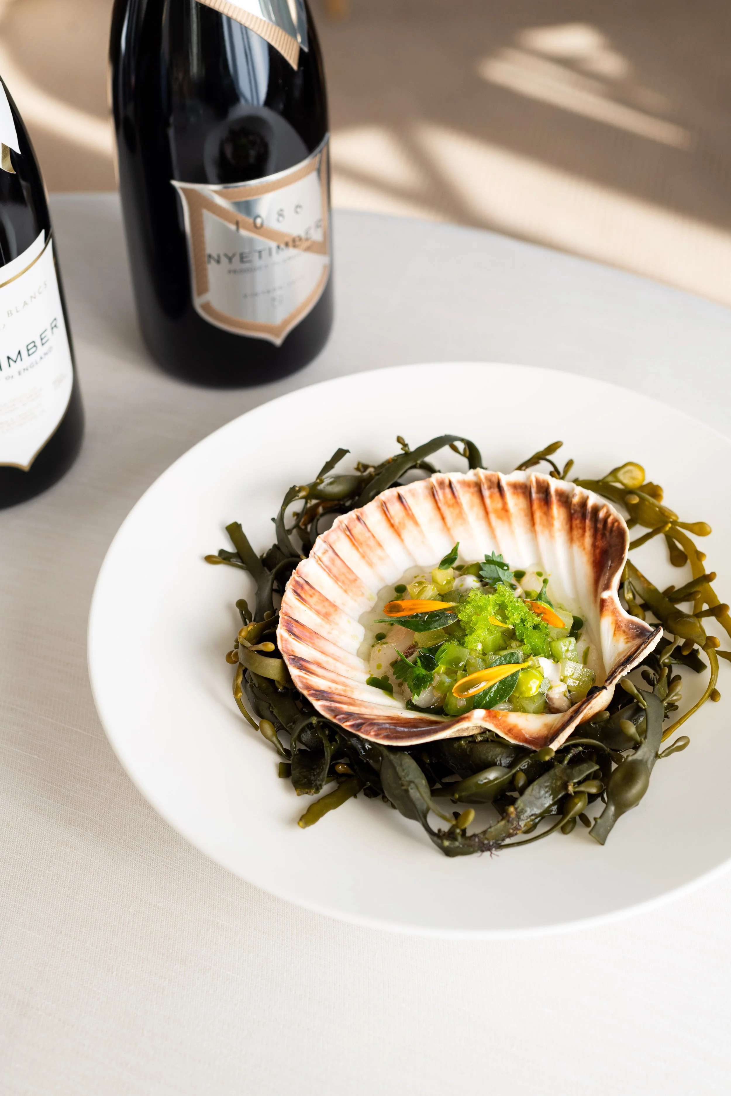 Scallop dish with 1086 by Nyetimber wine bottles at The Woodcote Wine Dinner.