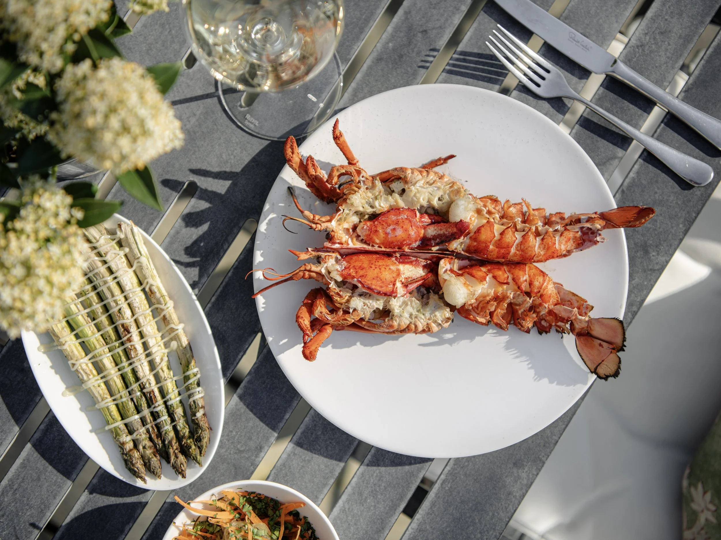 Luxury Father's Day menu at Woodcote featuring grilled lobster and seasonal asparagus, served al fresco.