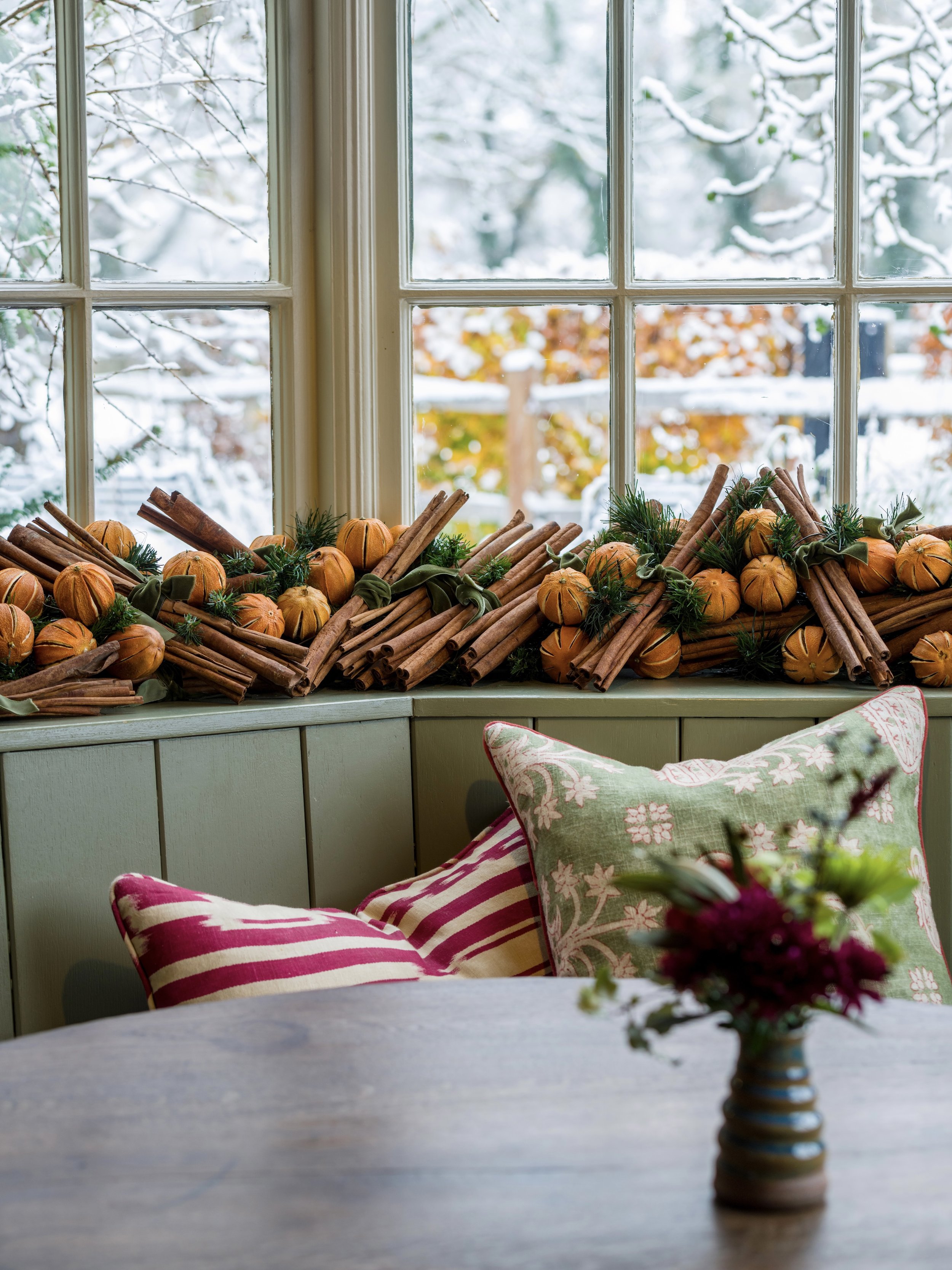 Dried oranges and cinnamon decorations beside a snowy window in The Woodcote restaurant in Graffham, West Sussex.