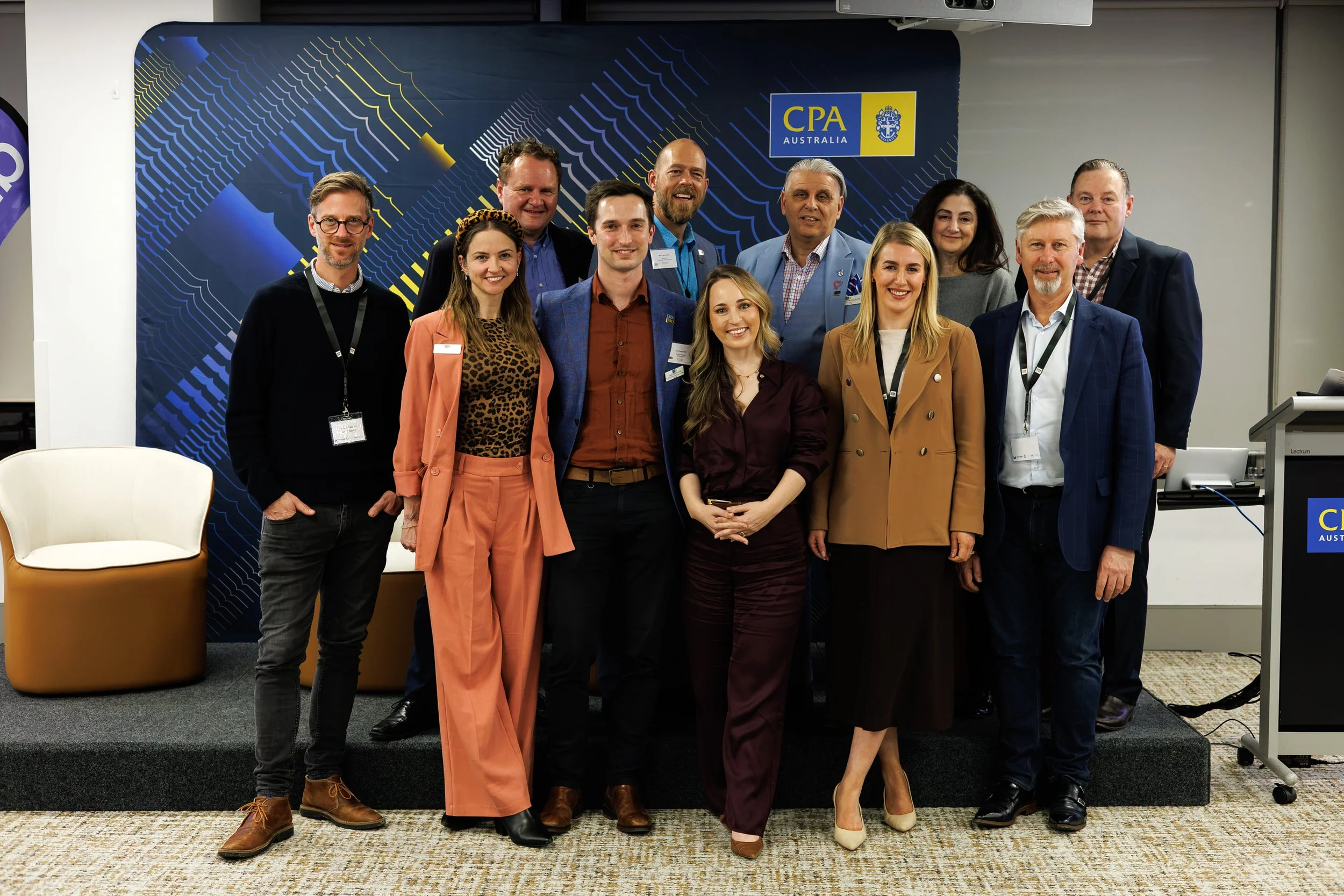 A group photo of the CPA Australia and IQ Club collaboration A Night To ACToN with a CPA Australia banner in the background.