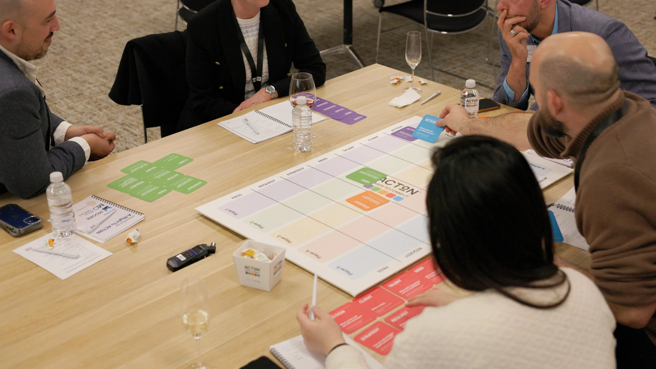 Group of people playing a strategic board game at a conference. Structured Speed Networking without the yelling.