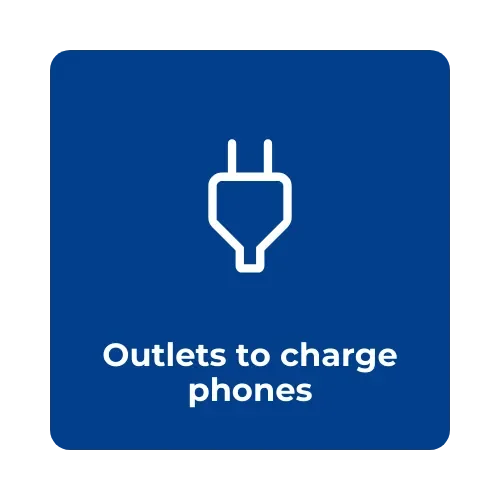 Blue sign with white outline of an electrical plug and text reading 'Outlets to charge phones'.