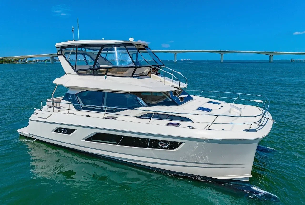 kokomo charters - 50' Memory Maker - A large white yacht floating on calm blue water with a bridge in the background under a clear blue sky.