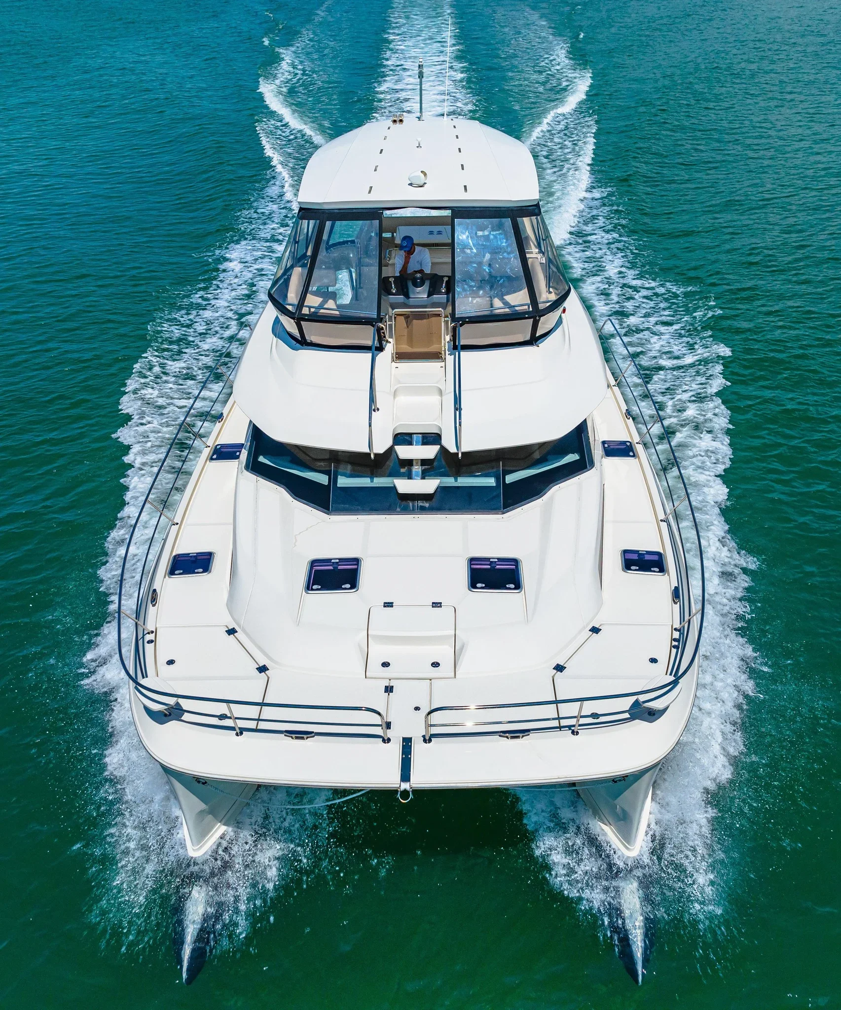 kokomo charters - 50' Memory Maker - A white motor yacht cruising on a calm body of water under a partly cloudy sky.