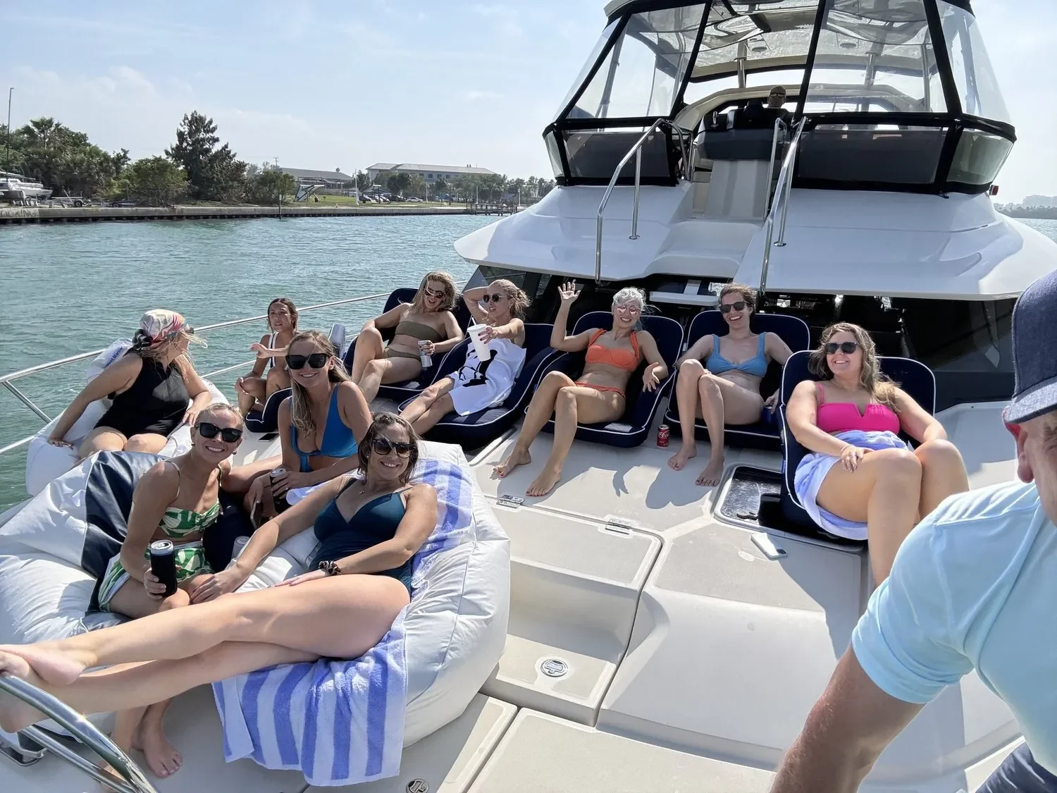 kokomo charters - rates -  A sleek 63' yacht with a spacious deck, cruising on open waters with passengers enjoying the view.