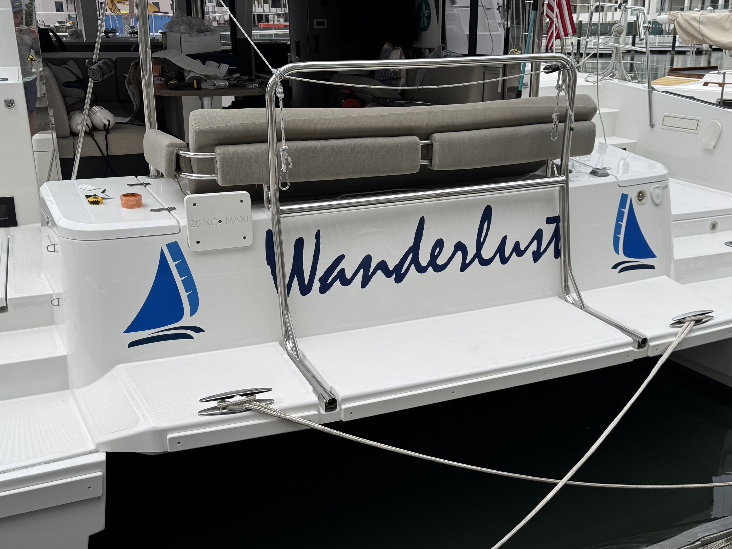 Back view of a sailboat named 'Wanderlust' at a marina.