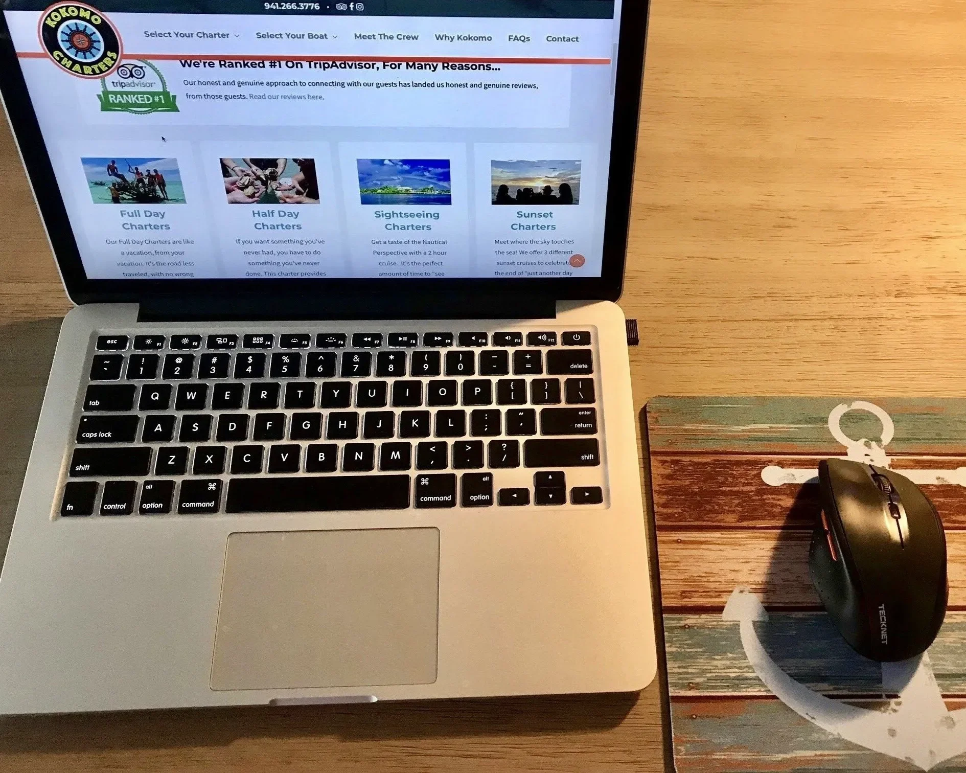 Corporate Outings – onboard workspace – laptop set up on yacht table showing remote work setup at sea.