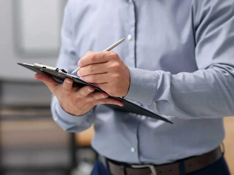 Business owner writing on clipboard, delegating tasks to invest in his business
