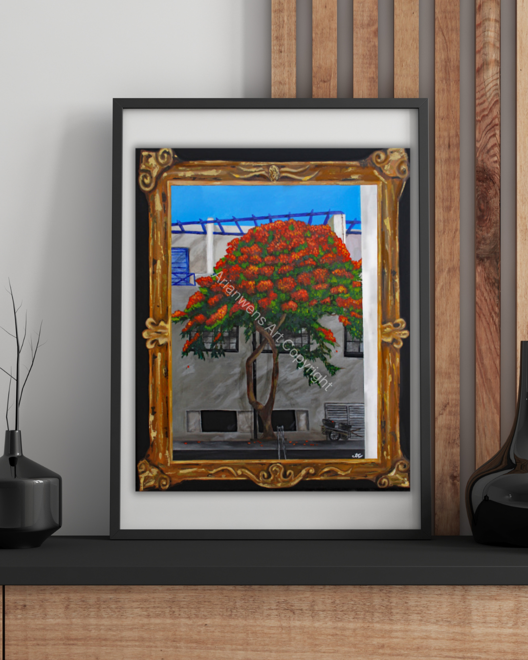 A print of a red flowered tree against a white building with blue shutters and doors