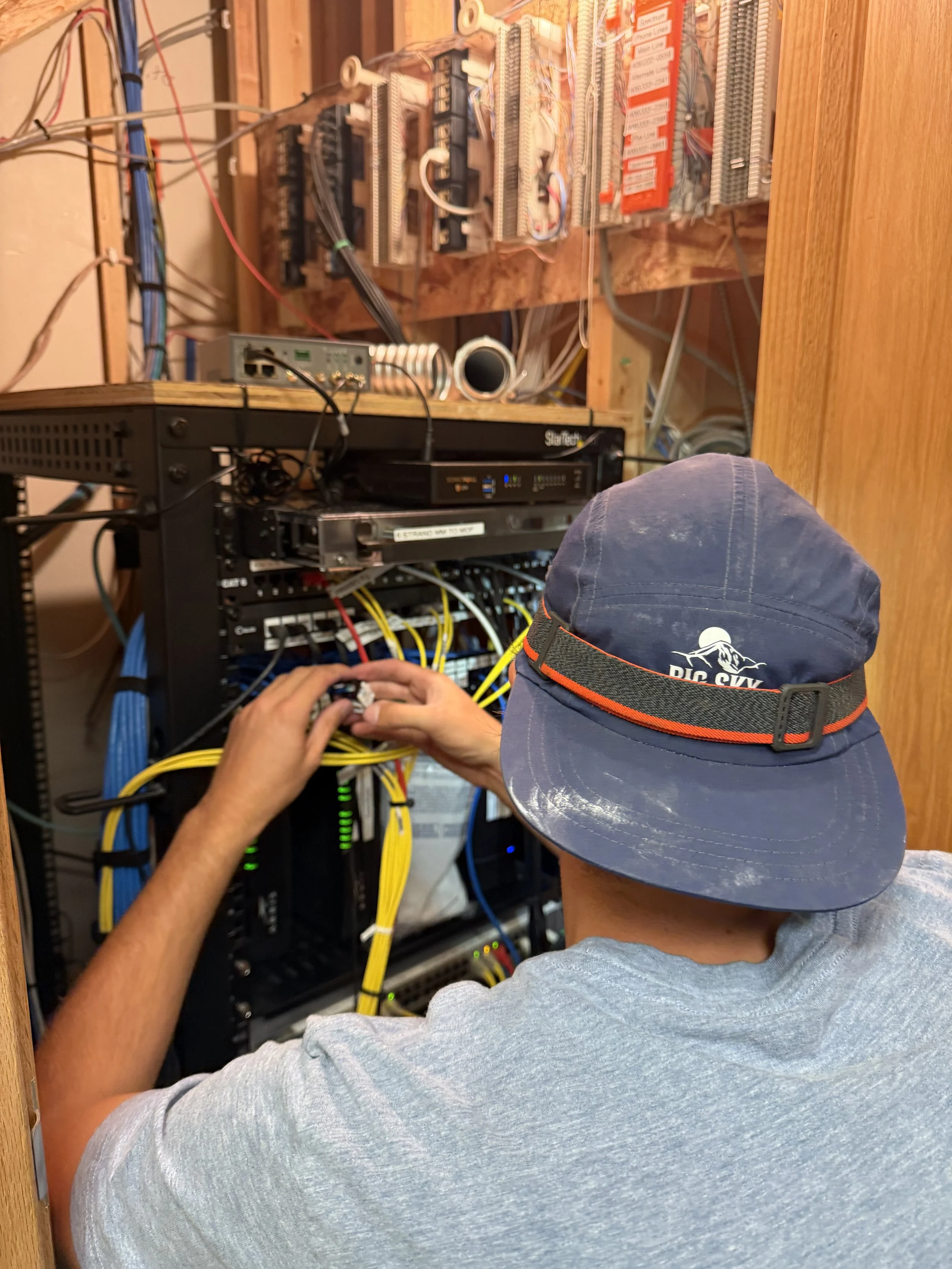 Big Sky Wired technician patching network cables in a rack
