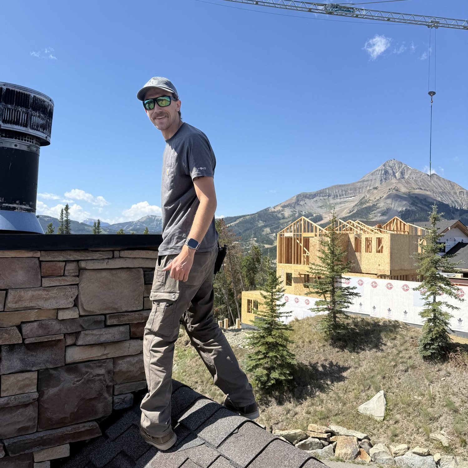 Big Sky Wired technician on a Big Sky rooftop during a Starlink install, with Lone Peak in the background