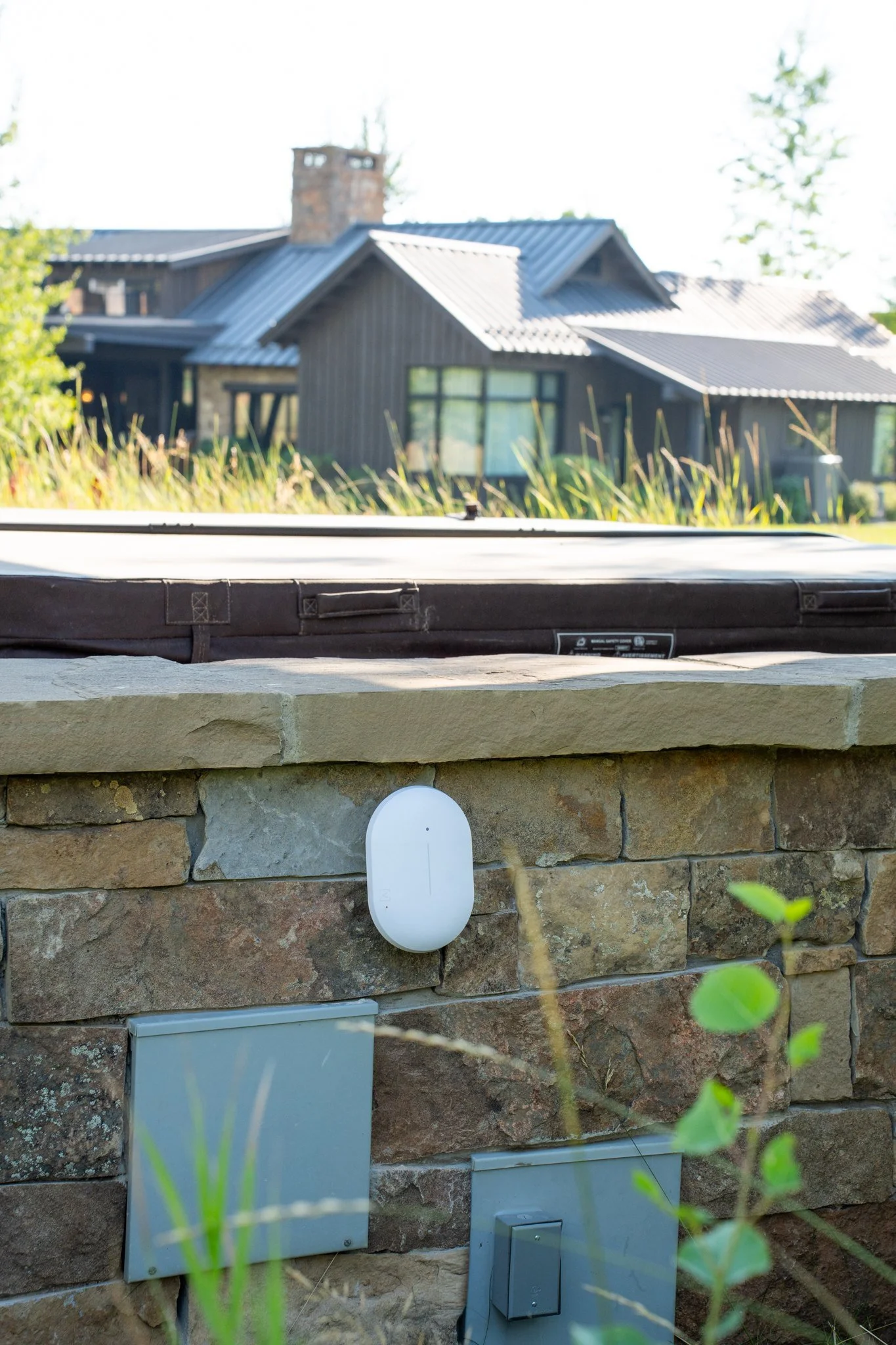 Outdoor WiFi access point on a stone wall at a Montana estate, with the house behind