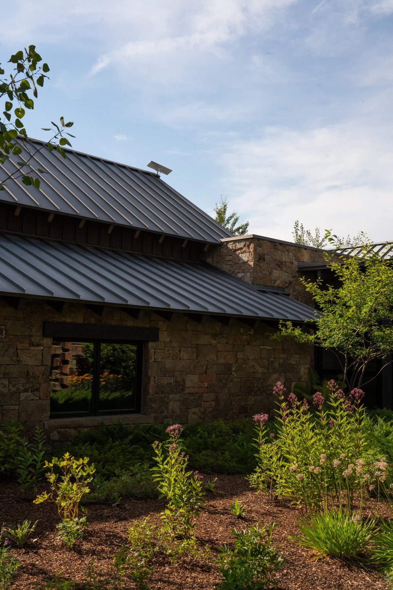 Stone and timber mountain home with a metal roof, networked by Big Sky Wired