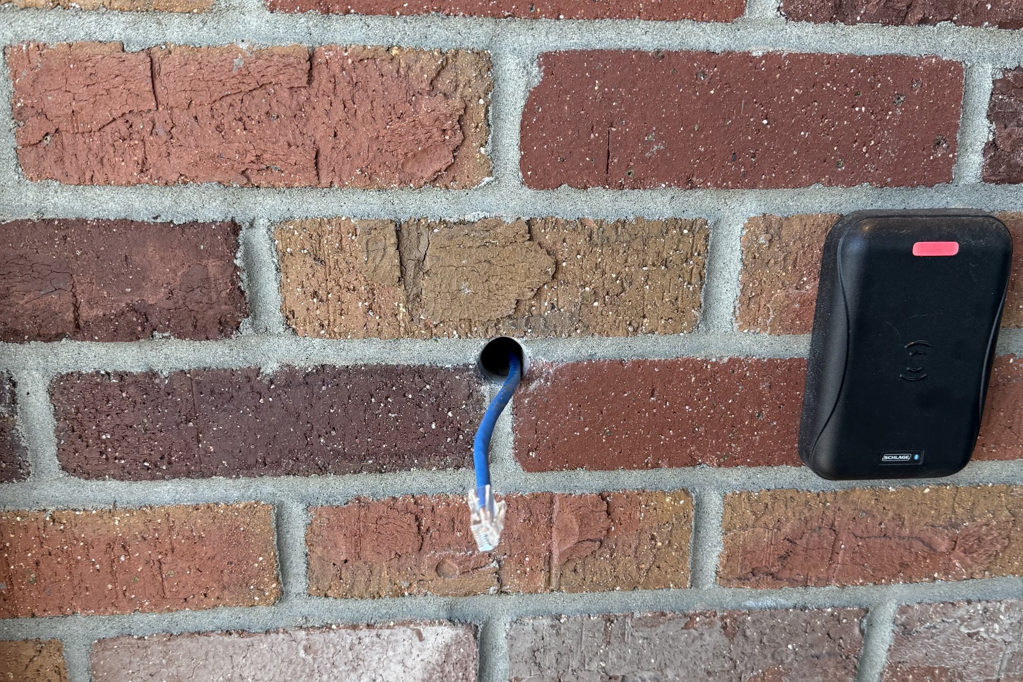 Card reader mounted beside a Cat6 cable stub waiting for its connection at a commercial entry