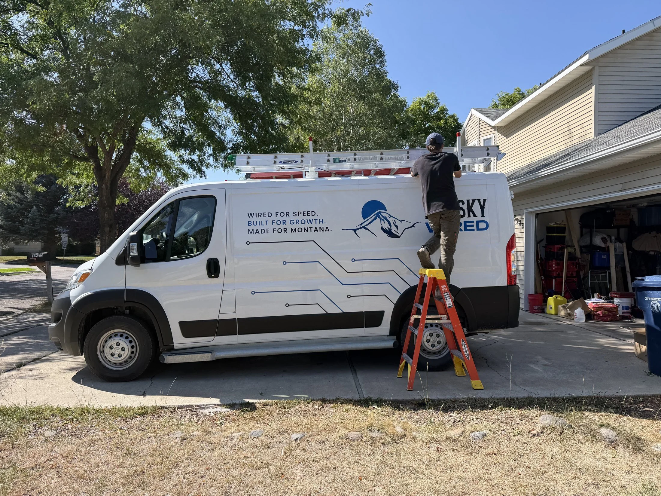 Big Sky Wired van and technician on a ladder during a home network install