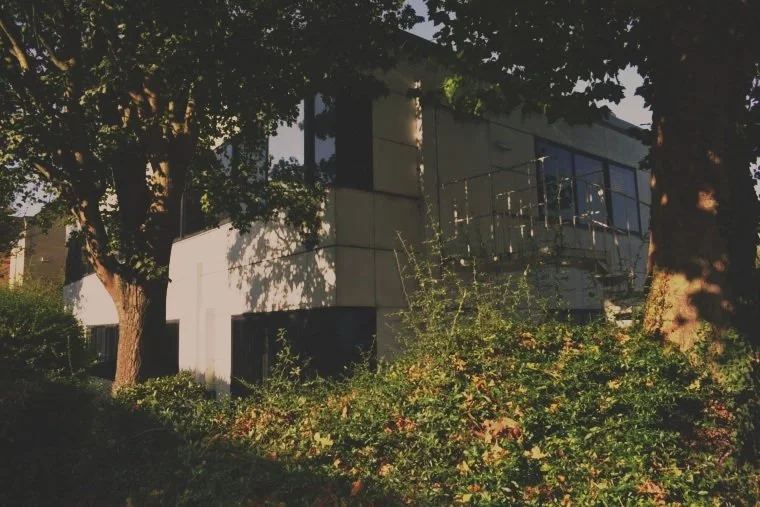 CCS from the roadside, large trees and bushes surround the building.