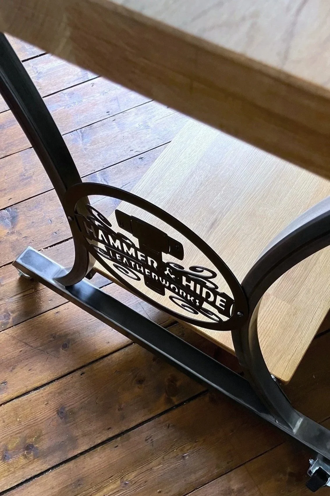 Photo of a metal legged table, featuring a decorative sign and a shelf underneath.