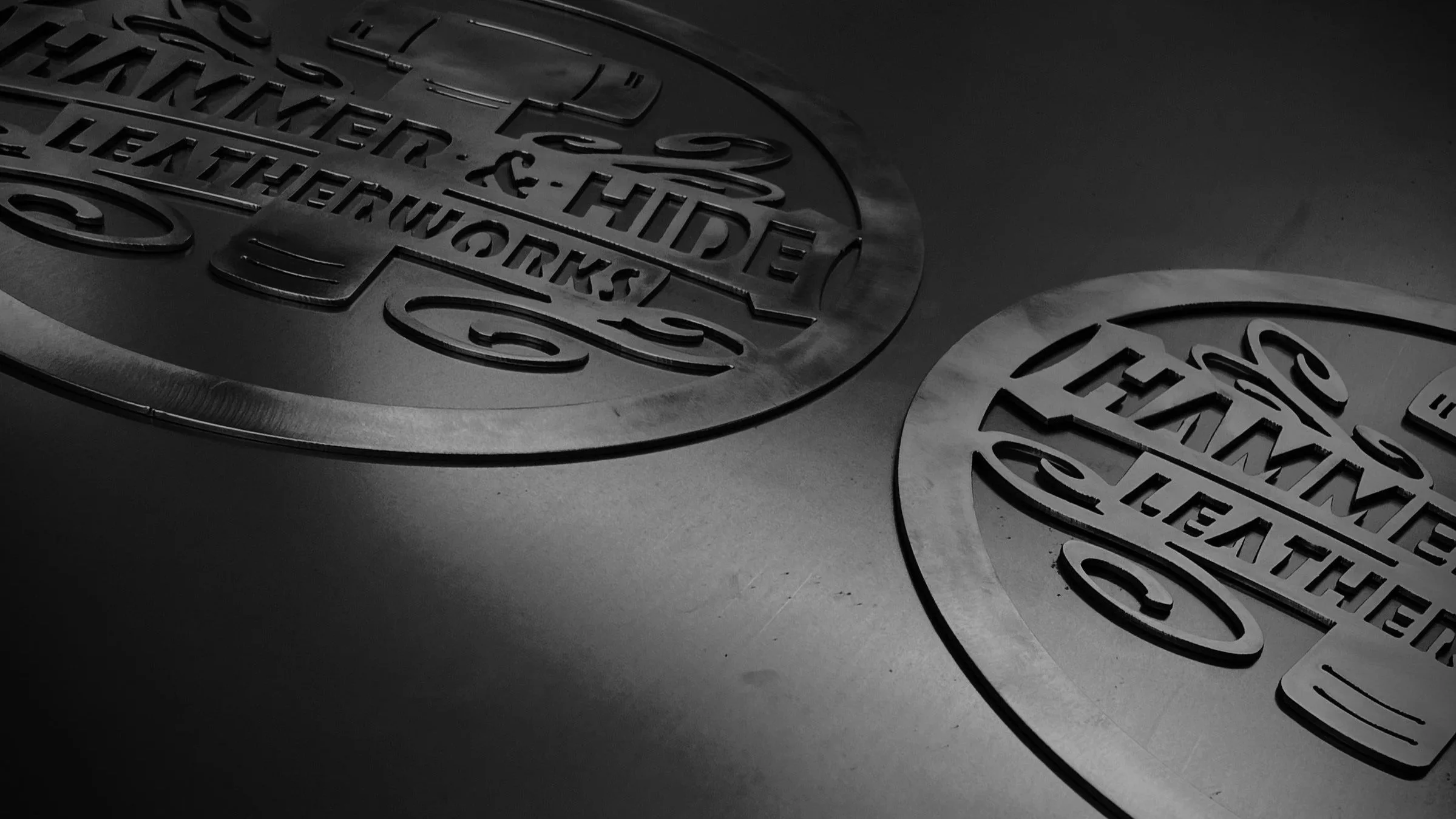 Close-up of a steel cut logos on metal surfaces in black and white.