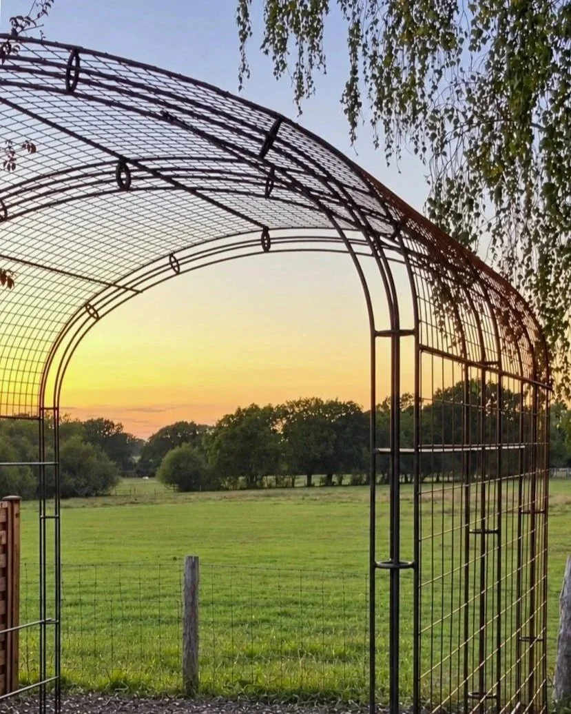 a gorgeous sunset shining through a steel arbour