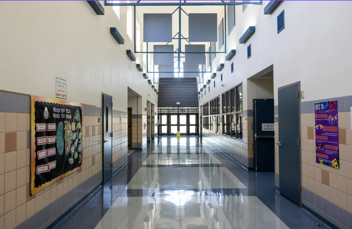 A parent and child walking through a school hallway together, highlighting the importance of emotional support during the transition to middle school.