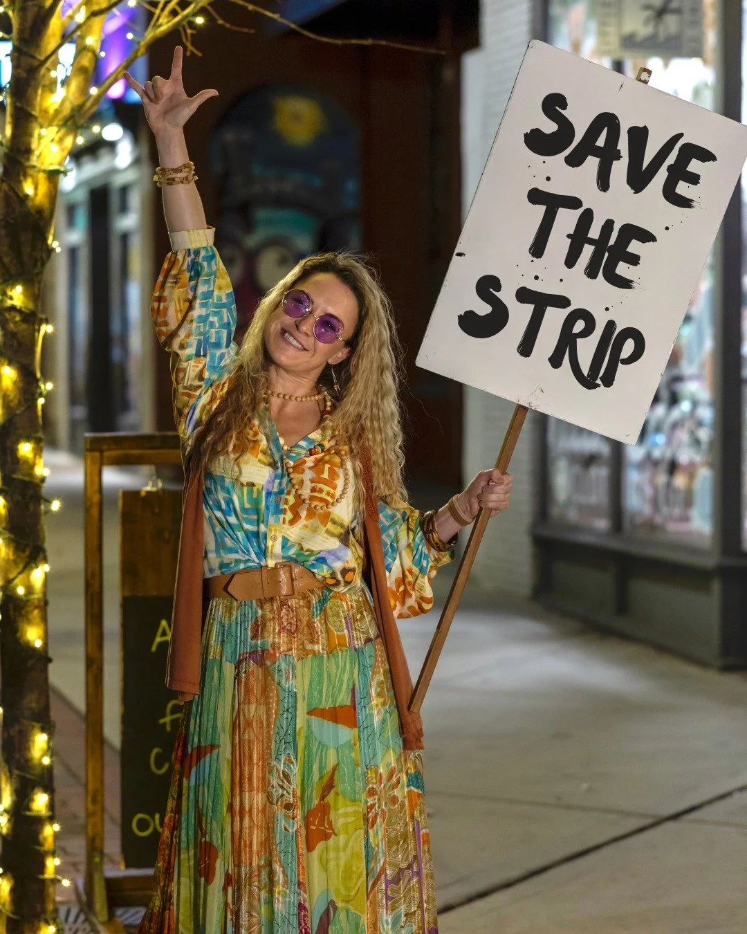 Regina is out in the streets and on a mission &mdash; megawatt energy, unstoppable optimism, and a hand-painted sign ready to Save the Strip! ✊💥 Kaitlin Baden (@kaitlin.baden) is bringing the fire, the fight, and the funniest chaos to #RockOfAges.

