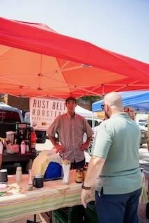  David Martin talking to a coffee roaster during the Last Stop Willoughby Festival. 
