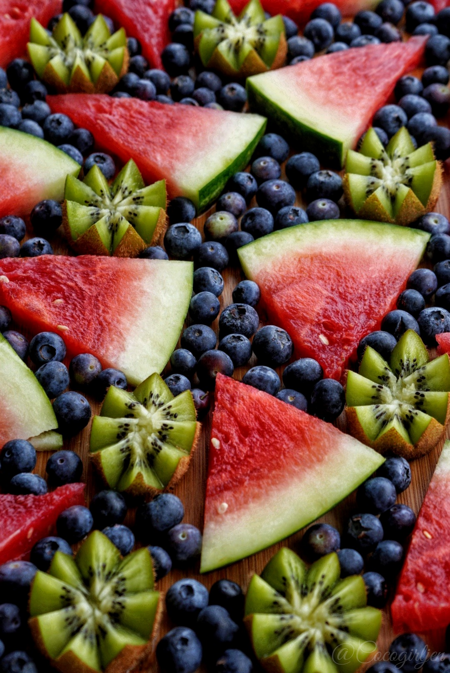 Aesthetic raw vegan fruit platter with cut watermelon, blueberries, and kiwis.