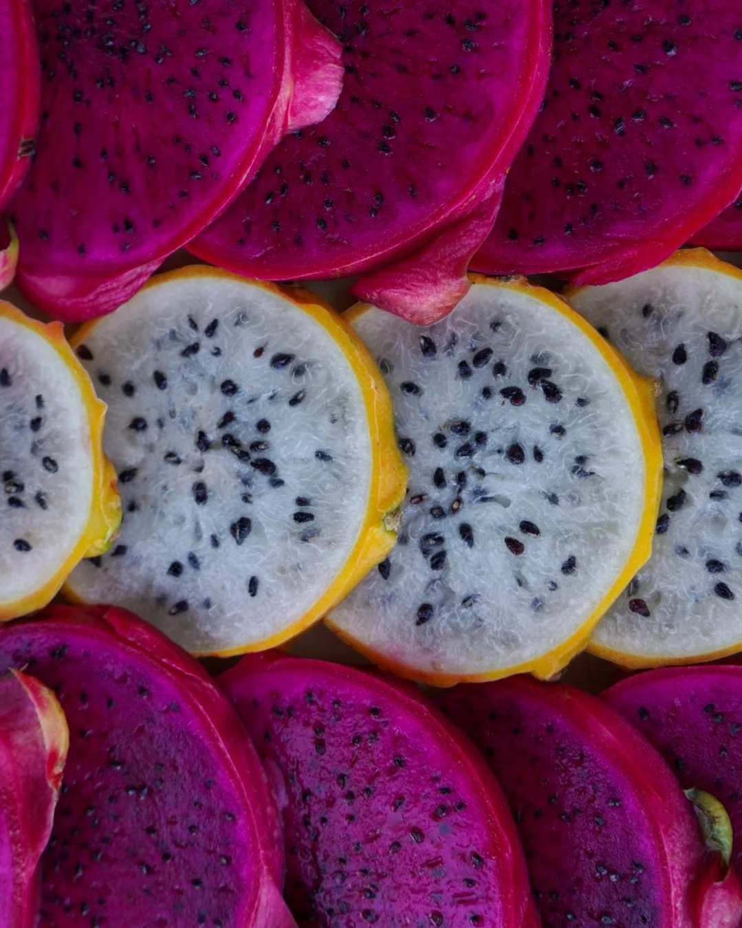 Close up of a raw vegan fruit platter composed of sliced red and yellow pitaya.