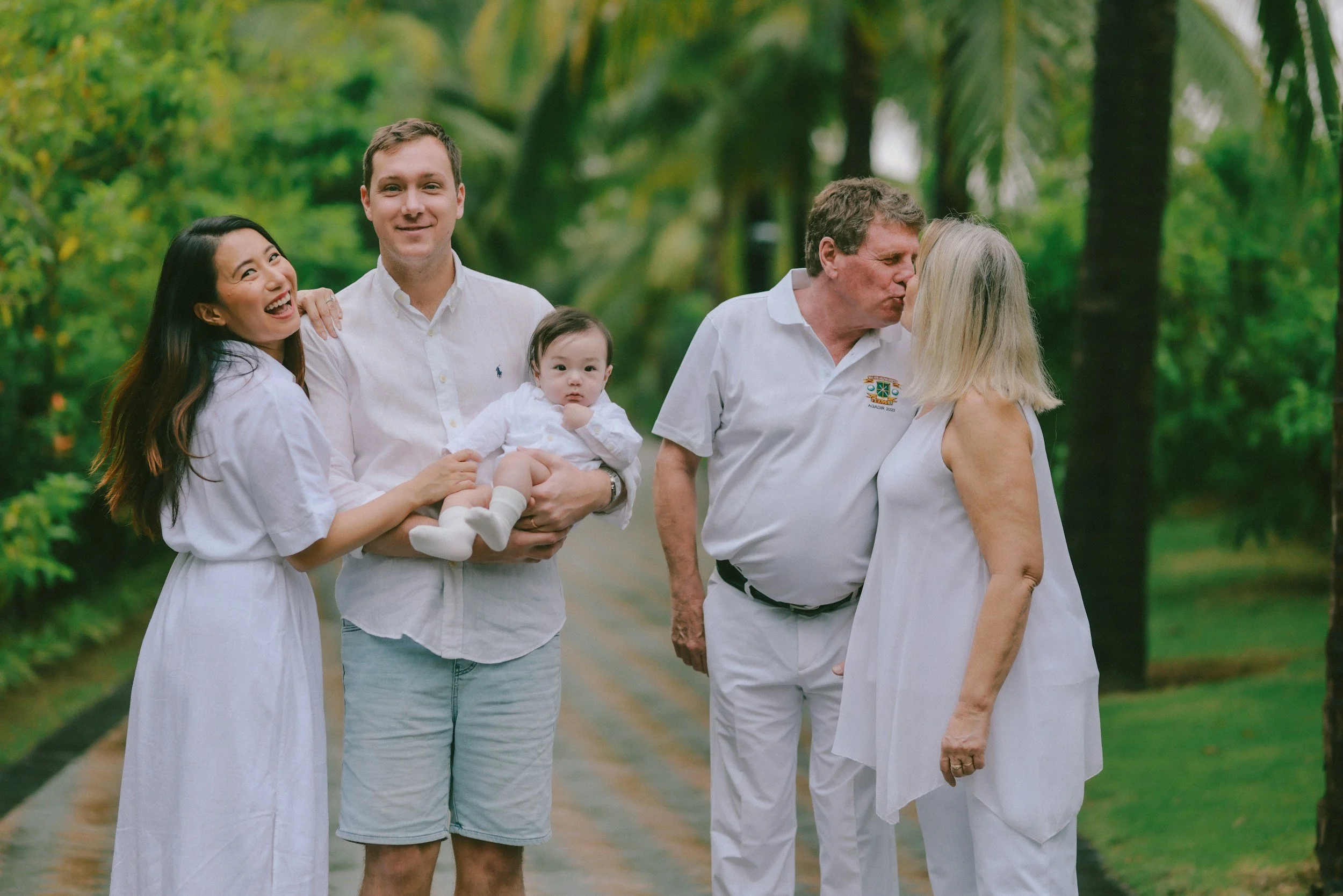 Multi-generational family members standing in a park together