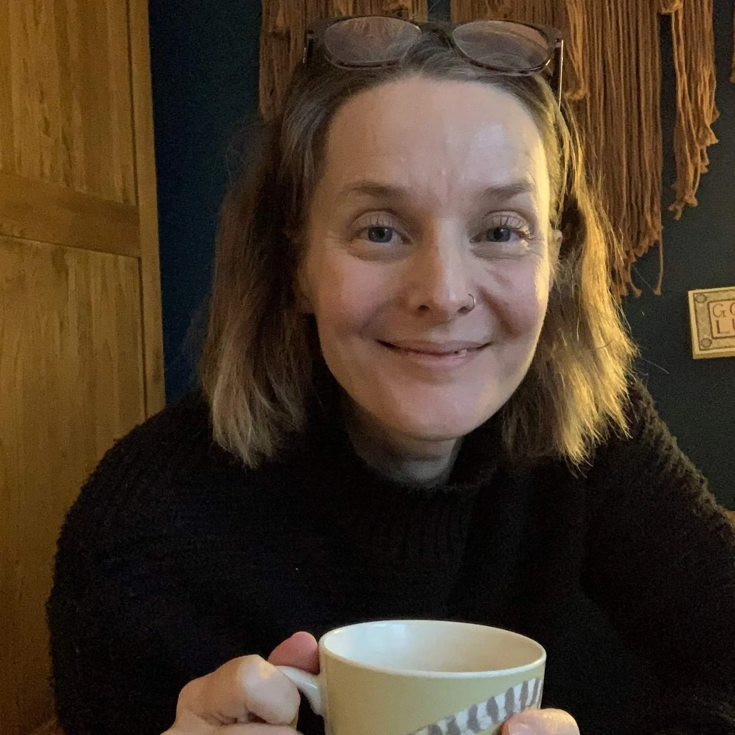 Founder of Harmony Healing Claire Buttrum looking into camera holding a cup of tea