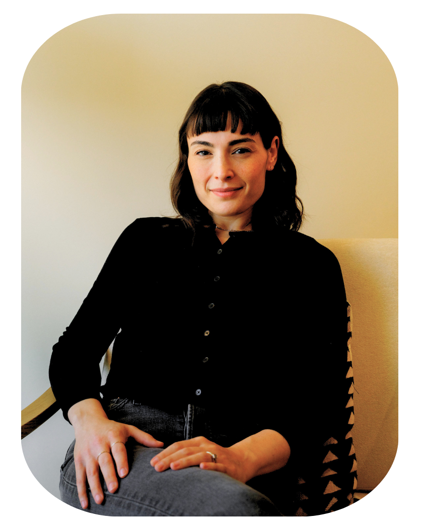 Sam Miller, LMFT, smiling while seated in her therapy office chair